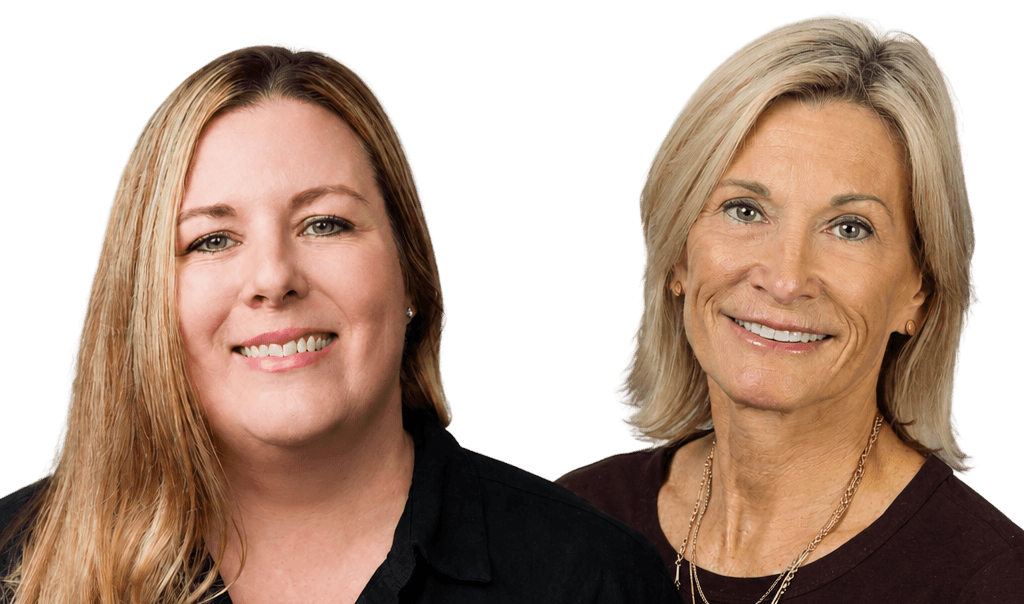Two smiling women with silver hair in vibrant blazers.